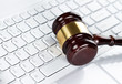 Close up of wooden gavel at the computer keyboard Close up of wooden gavel at the computer keyboard
