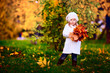 Photo: little girl in warm cardigan smiling against the background of f little girl in warm cardigan smiling against the background of f