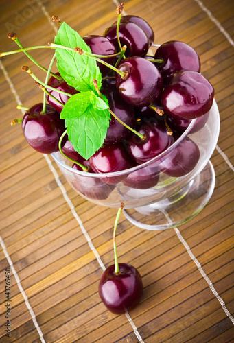 Photo: Sweet cherry fruits in glass goblet with mint leaf Sweet cherry fruits in glass goblet with mint leaf