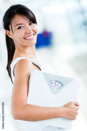 Photo: Woman holding a weight scale Woman holding a weight scale
