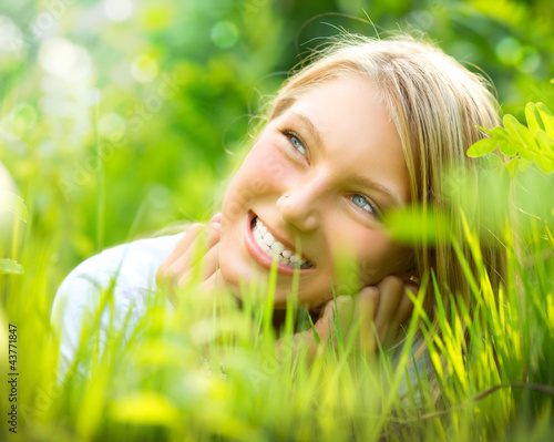 Photo: Beautiful Smiling Girl in Green Grass Beautiful Smiling Girl in Green Grass