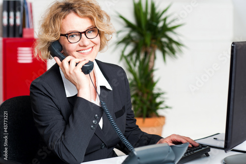 Photo: Front desk lady attending clients call Front desk lady attending clients call