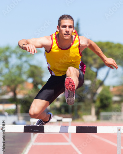 Photo: Male Track and Field Athlete during Obstacle Race Male Track and Field Athlete during Obstacle Race