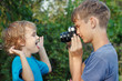 Young photographer with a camera shoots her little brother