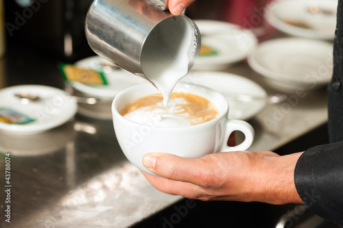 Photo: Barista bereitet Cappuccino zu in seinem Cafe Barista bereitet Cappuccino zu in seinem Cafe