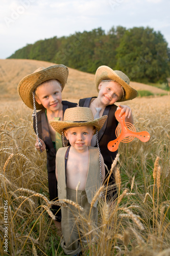 Photo: Three brothers playing field wheat. Twins. Smiling big family. Three brothers playing field wheat. Twins. Smiling big family.