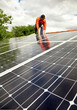 Electrician checking solar panels on roof