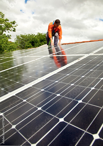 Photo: Electrician checking solar panels on roof Electrician checking solar panels on roof
