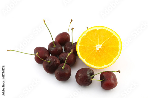 Photo: Half navel orange and cherry on white background Half navel orange and cherry on white background