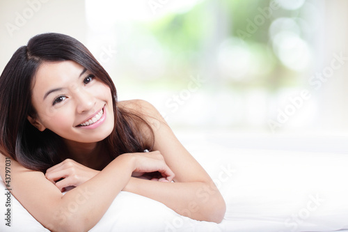Photo: Charming woman Smile face and lying on bed Charming woman Smile face and lying on bed