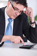 Photo: Worried businessman calculating Worried businessman calculating
