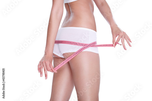 Photo: Slim girl measuring her hips Slim girl measuring her hips
