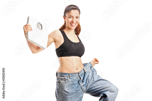 Foto: A weightloss woman holding a weight scale A weightloss woman holding a weight scale