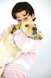 Young man kissing his puppy dog labrador