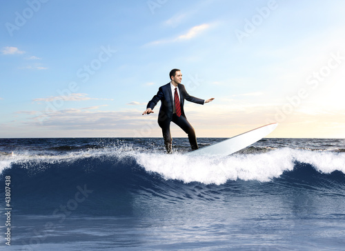 Foto: Young business person surfing on the waves Young business person surfing on the waves