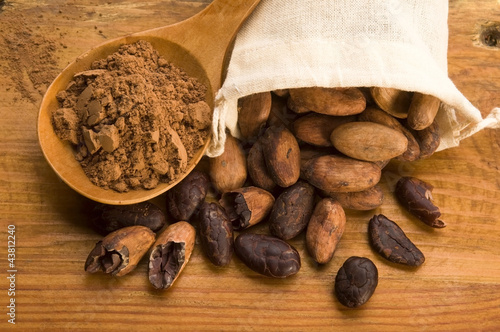 Photo: Cocoa (cacao) beans on natural wooden table Cocoa (cacao) beans on natural wooden table
