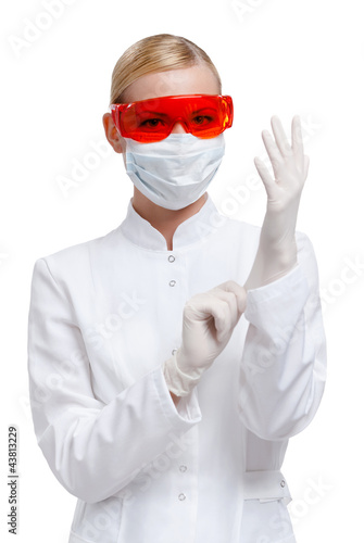 Photo: Female practitioner puts on medical rubber gloves Female practitioner puts on medical rubber gloves