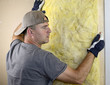 Photo: Man installing fiberglass insulation Man installing fiberglass insulation