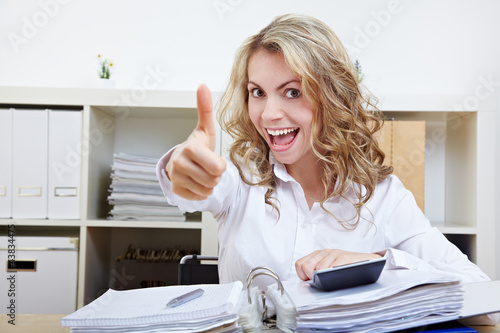 Photo: Frau im Büro hält Daumen hoch Frau im Büro hält Daumen hoch