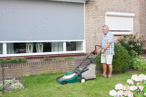 Photo: Dutch senior mowing lawn Dutch senior mowing lawn