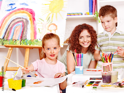 Photo: Child painting at easel. Child painting at easel.