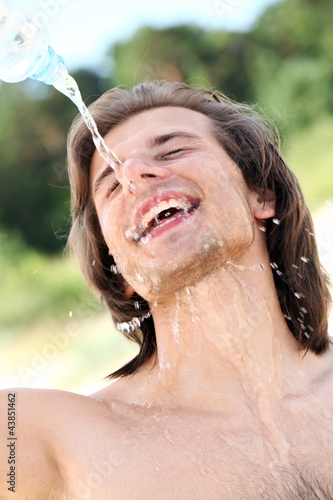 Foto: Happy guy pouring water on his face Happy guy pouring water on his face