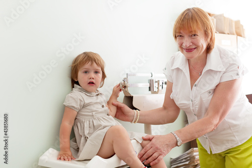 Photo: pediatrician weighs the baby pediatrician weighs the baby