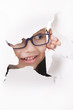 Curious kid looks through a hole in paper