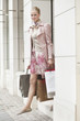 Woman exiting a store with shopping bags