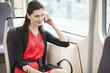 Woman traveling in a tram and talking on a mobile phone