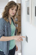 Woman pressing light switch on a wall