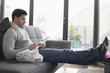 Man sitting on a couch reading medical prescription