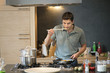 Man tasting food in the kitchen