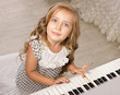 little girl sitting near the piano