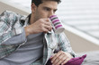 Man reclining on a couch and drinking coffee