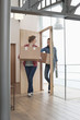 Female friends carrying cardboard boxes at home
