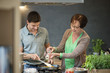 Woman assisting her son to cook food