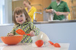 Cute little girl with slotted spoon and mixing bowl in the kitchen