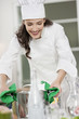 Female chef placing a saucepan on a dining table