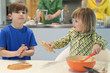 Children cooking in the kitchen with their parents in the background