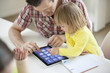 Man teaching digital tablet to his daughter
