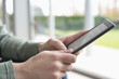 Close-up of a man's hand holding a digital tablet