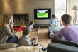 Family using electronic gadgets in a living room