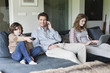 Family using electronic gadgets in a living room