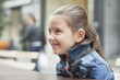 Close-up of a girl sitting at a sidewalk cafe