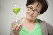 Woman looking at an hourglass