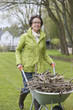 Woman pushing a wheelbarrow full of branches