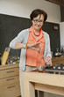 Elderly woman preparing herbal tea in the kitchen