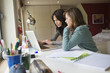 Girl studying with her mother on a laptop at home