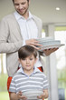 Man and son arranging plates for lunch